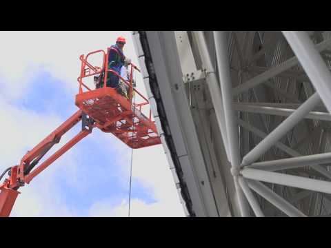Long Shot, construction workers ascending on an elevated …